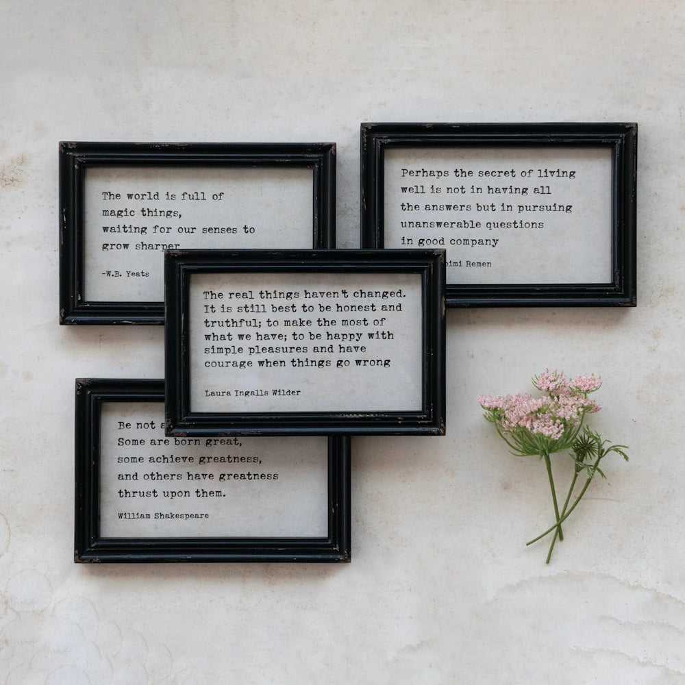 Four black-framed wall art pieces featuring literary quotes by Yeats, Wilder, and Shakespeare with pink flowers.