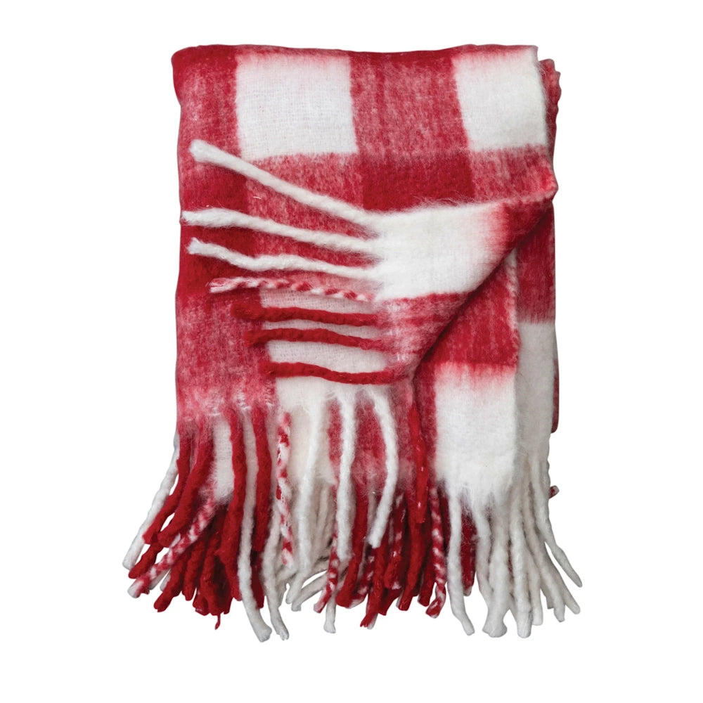 Folded red and white plaid throw blanket with soft, long fringe trim.
