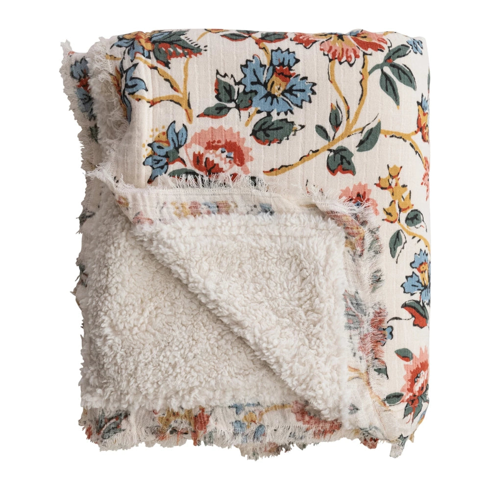 Floral print throw blanket with cream sherpa fleece lining and frayed edges for cozy home decor.