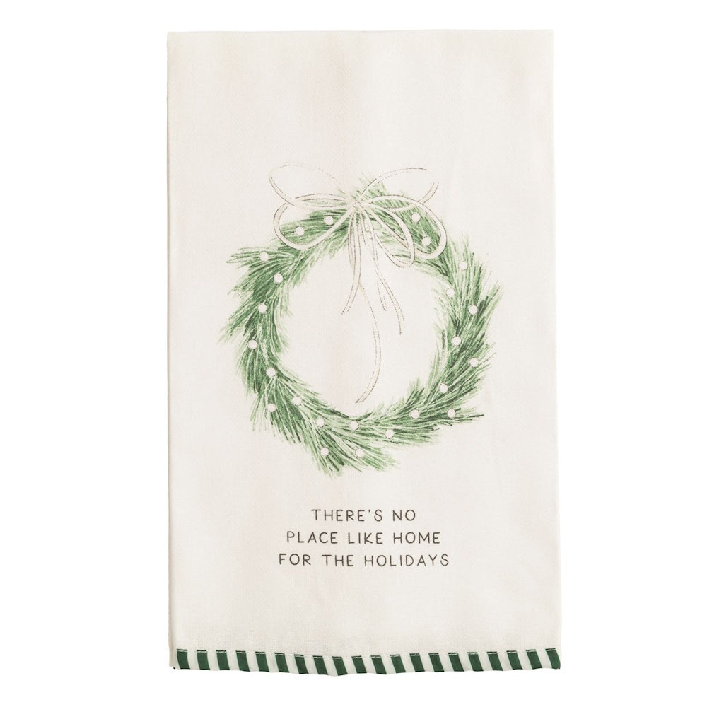 White towel featuring a green wreath with a white bow and "THERE'S NO PLACE LIKE HOME" text.