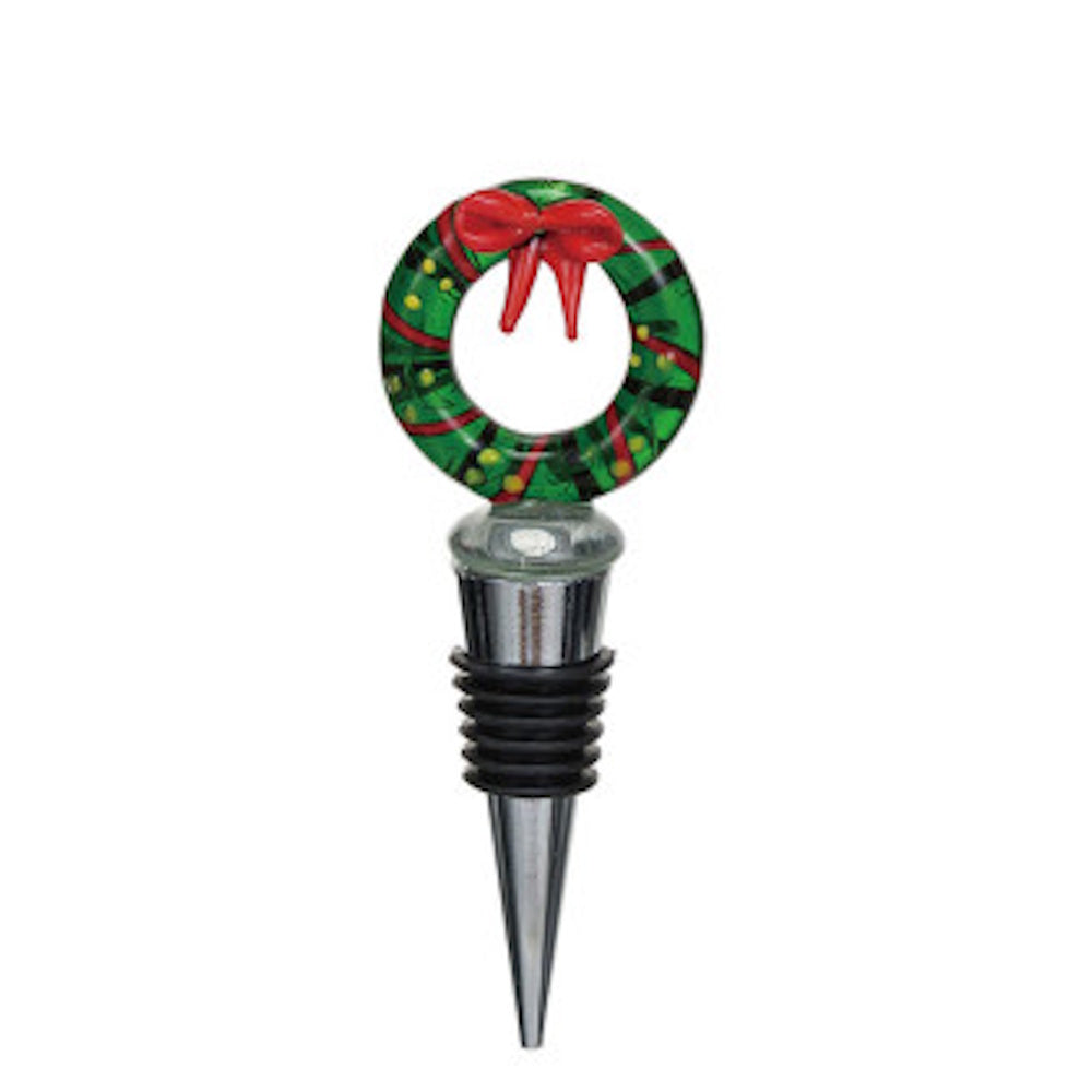 Christmas wreath bottle stopper featuring a green wreath design with a red bow and a ribbed metal and rubber base.