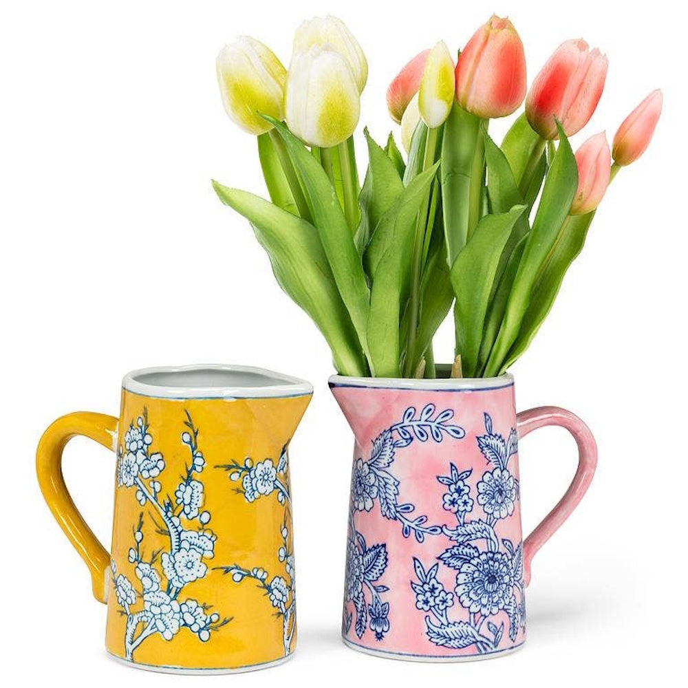 Yellow and pink ceramic floral jugs with fresh tulips, used as small decorative flower vases.