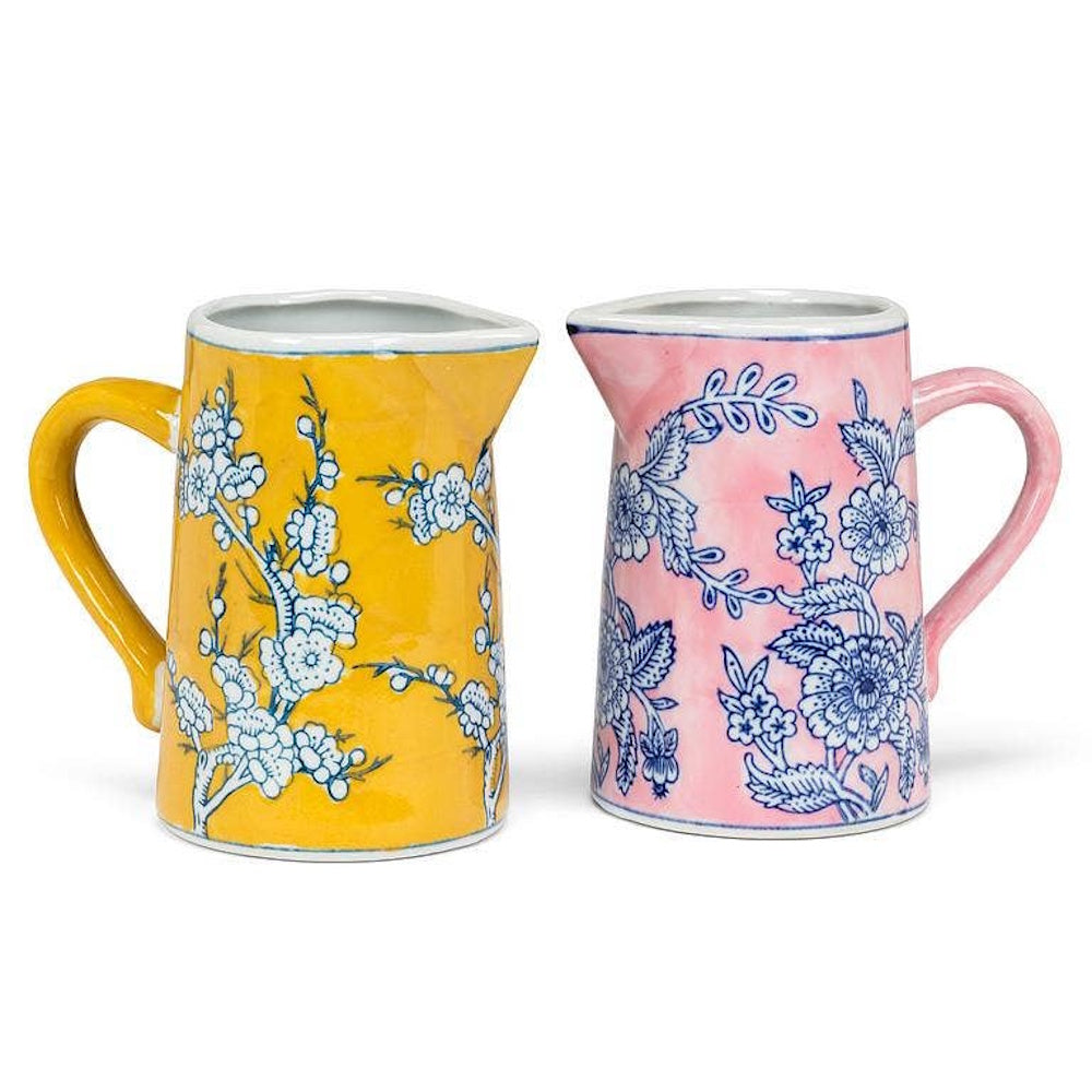 Yellow and pink ceramic mini pitchers with blue floral chinoiserie patterns.