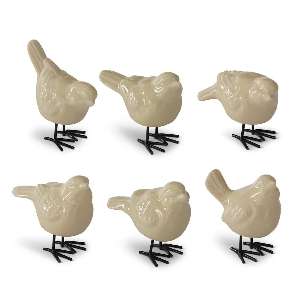 Set of six cream-colored porcelain bird figurines with black metal legs on a white background.